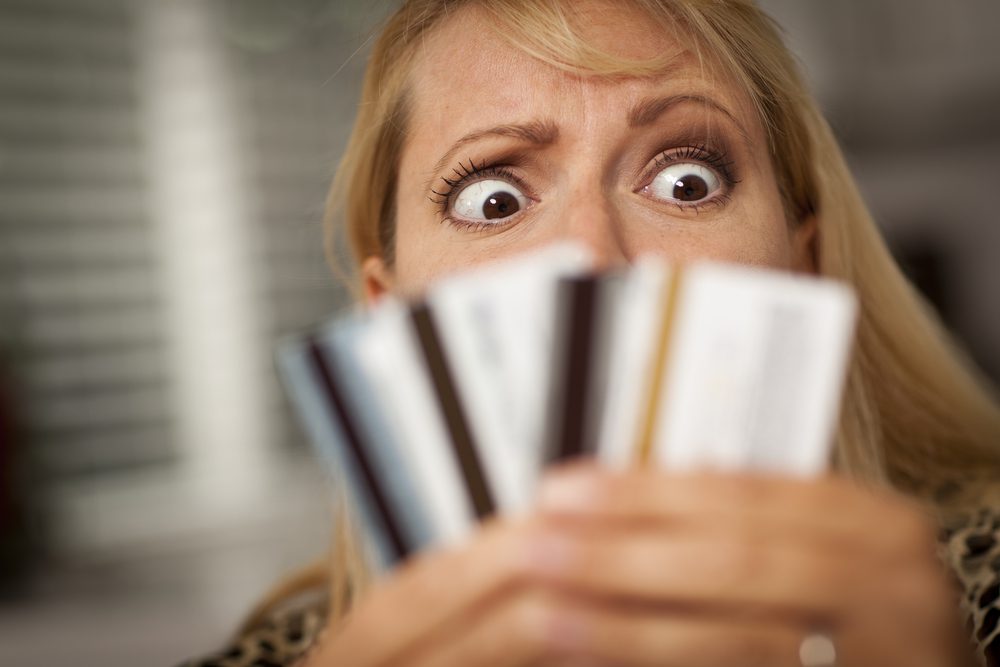 Woman glaring at three credit cards.