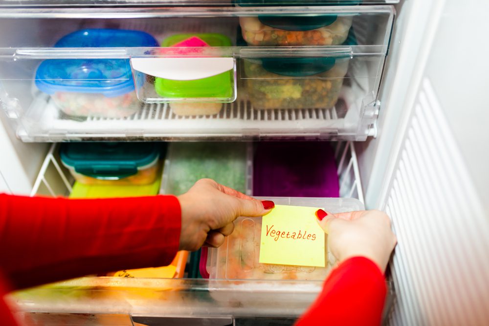 Placing a vegetable sticky note on frozen food. 