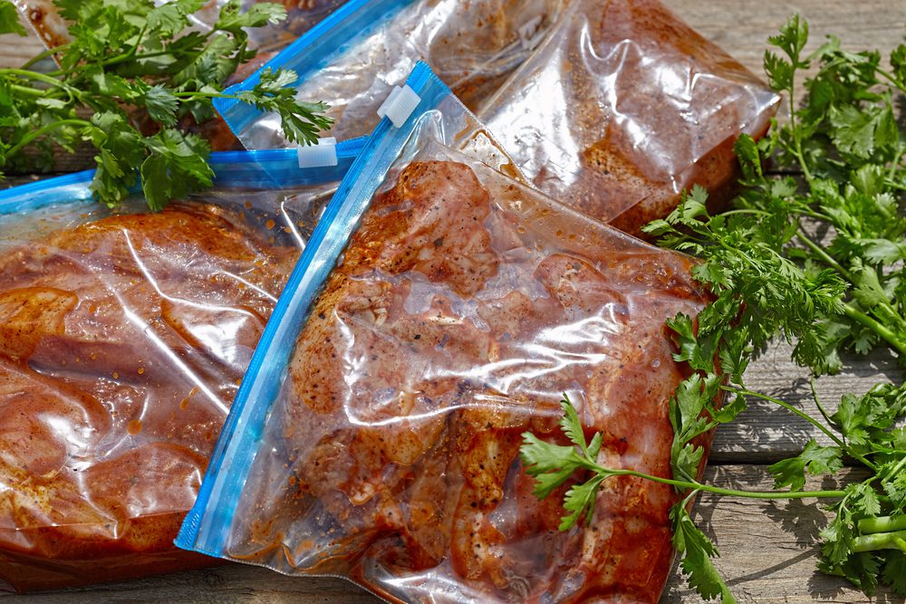 Bagged and marinated meat with some parsley. 