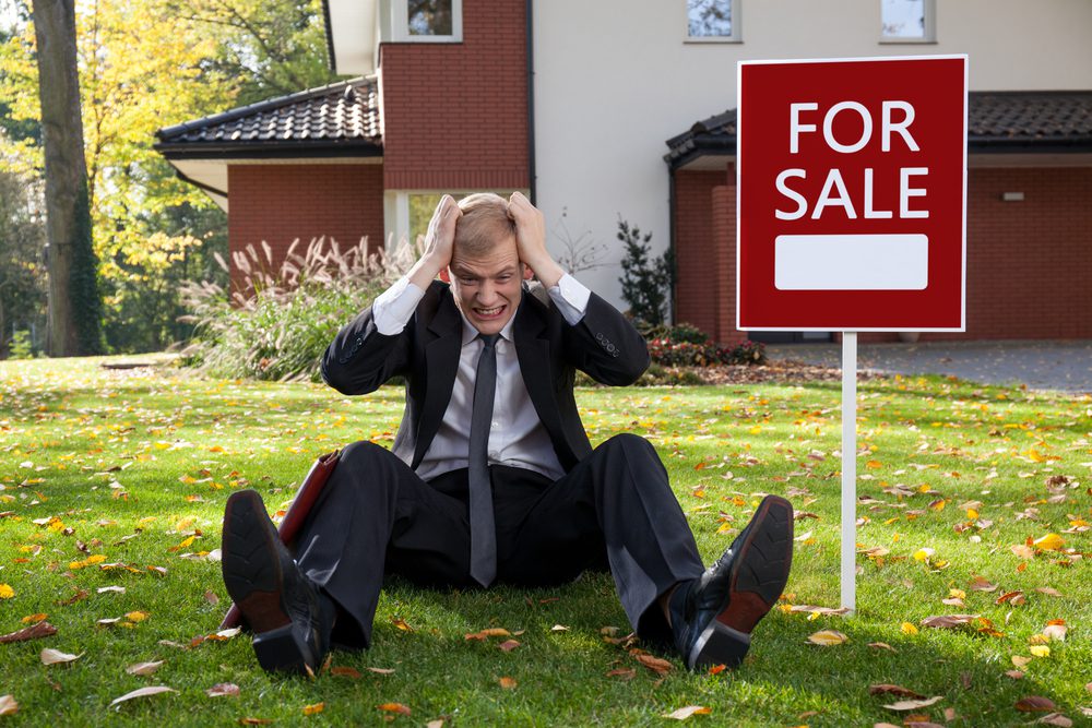 Frustrated real estate agent on the ground.