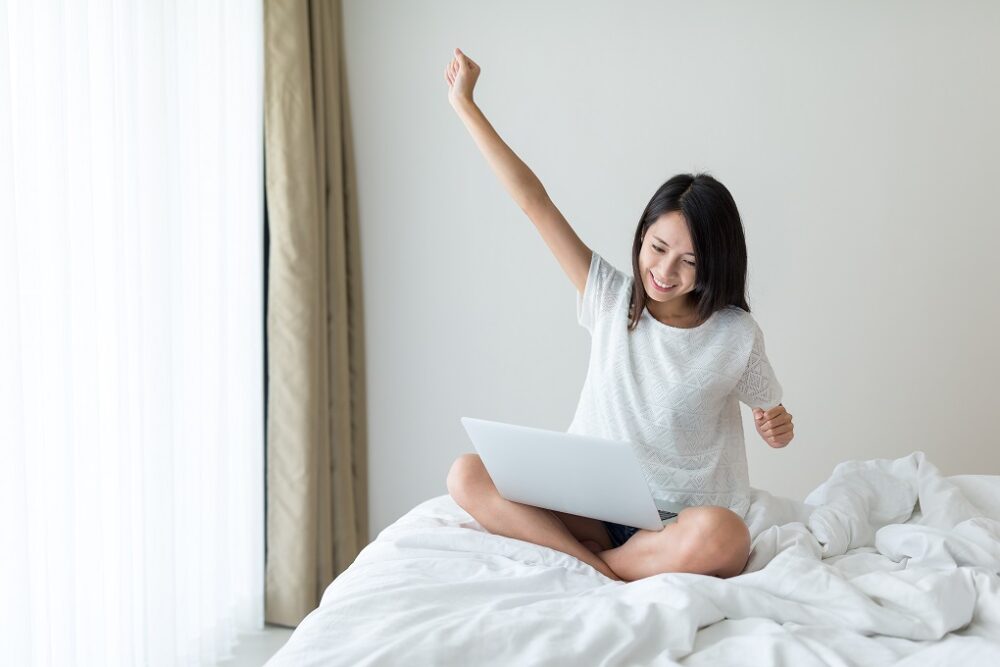 Excited woman using notebook computer